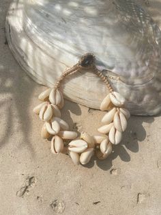 Introducing our new beach accessory: the OCEAN COWRIE SEASHELL BRACELET. Crafted with natural shells sourced from the depths of the ocean in Thailand, this statement piece beautifully captures the essence of the sea. Each shell is carefully combined to create a captivating and unique representation of oceanic beauty. Perfect for beach outfits, honeymoons, resort wear, or gift for your love ones, this choker necklace is a versatile addition to your wardrobe. What sets it apart is our commitment to sustainability and our dedication to working directly with our makers. By choosing this bracelet, you're not only enhancing your style but also supporting ethical craftsmanship and caring for the world. Elevate your beach look with this stunning, eco-friendly accessory and feel good about your imp Ocean-inspired Abalone Shell For Beach, Bohemian Cowrie Shell Bracelet, Cowrie Shell Beaded Bracelets As Gift, Adjustable Ocean-inspired Shell For Beach Season, Unique Abalone Shell Necklace For Beach, Ocean-inspired Abalone Shell Decor, Adjustable Coastal Style Shell Strand, Bohemian Cowrie Shell Strand Bracelet, Abalone Shell Necklace For Beach