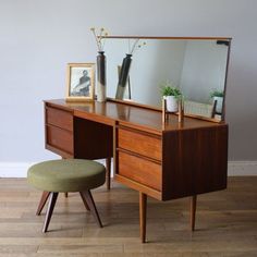 a wooden desk with a mirror and stool