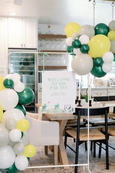 some balloons are hanging from the ceiling in front of a dining room table and chairs