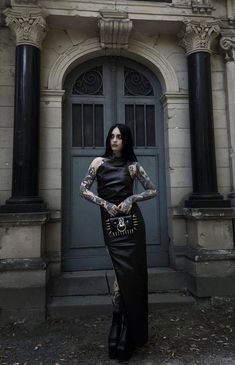 a woman with tattoos standing in front of a building