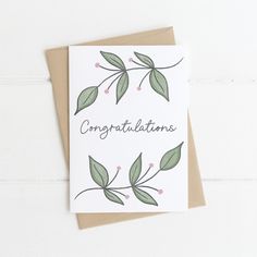 congratulations card with green leaves and pink berries on the front, against a white background