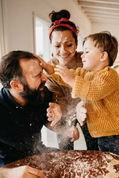 a man, woman and child are playing with flour