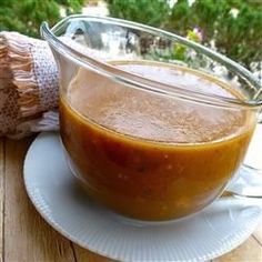 a bowl of sauce sitting on top of a white plate