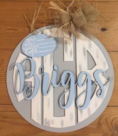 a wooden sign with the word, biggs on it and an angel above it