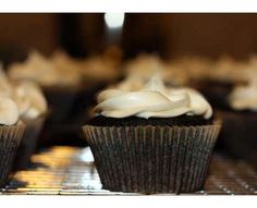 cupcakes with white frosting sitting on cooling racks