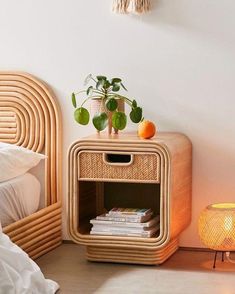 a bed room with a neatly made bed next to a night stand and a wicker nightstand