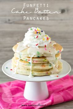 a stack of pancakes topped with whipped cream and sprinkles on a white plate