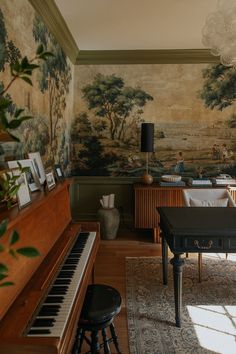 a living room filled with furniture and a piano in front of a painting on the wall