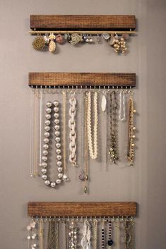 several necklaces are hanging on the wall in front of two shelves with earring hooks