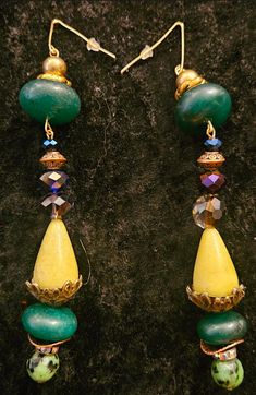 5" in length; I would assess these to be in-between light and moderate in weight (the agate and emeralds add density). Components inlclude shiny gold tone balls, fancy gold tone swirled rings, emerald rondelles, various faceted crystals, yellow agate teardrops, ornate bronze tone bead caps, rhinestone rondelles, burnished antique copper potato chip metal spacers and faceted ruby zoisite. All the beads are on pliable yet sturdy metal wires which can readily be straightened, if need be. Attached to a thin metal gold tone hook with a silicone back to protect against loss while wearing. OOAK Wearable Art from the Atelier of Kat Kouture! Unique Green Long Drop Earrings, Handmade Green Agate Earrings, Unique Dangle Earrings With Gemstone Beads, Unique Green Long Drop Jewelry, Elegant Green Agate Earrings, Unique Jade Drop Earrings, Artisan Green Czech Glass Earrings, Spiritual Green Earrings With Natural Stones, Green Spiritual Earrings With Natural Stones