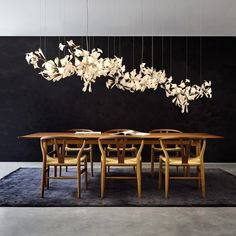 a dining room table with chairs and a chandelier hanging from the ceiling above it