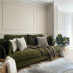 a living room with a green couch and rugs on the floor next to a window