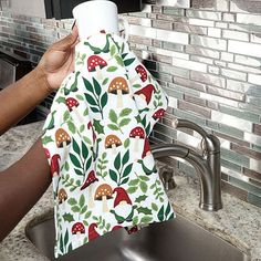 a person holding a napkin over a kitchen sink