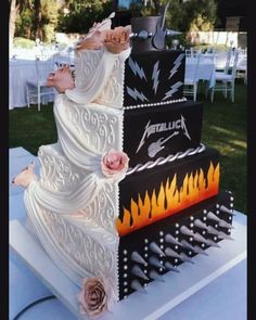 a three tiered wedding cake with pink roses on top and an iron maiden design