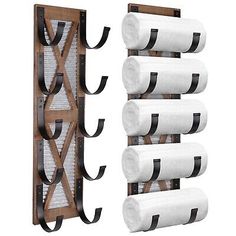 a wooden rack with four rolls of toilet paper hanging on the wall next to it