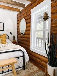 a bedroom with wooden walls and white bedding