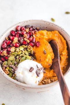 a bowl filled with mashed potatoes, pumpkin puree and pomegranate