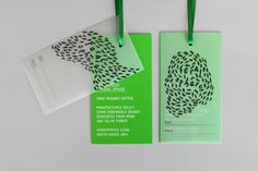 two green tags with black and white designs on them