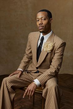 a man in a suit and tie sitting on a chair