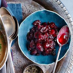 a bowl of cranberry sauce and spoons on a tray