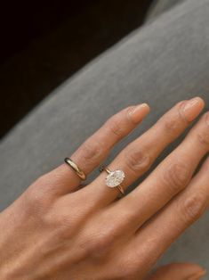 a woman's hand with two rings on her fingers and one ring in the middle