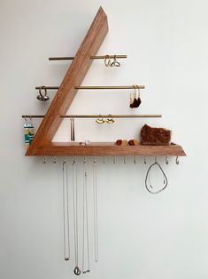 a wooden shelf with various items hanging from it's sides and hooks attached to the wall