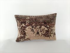 a decorative pillow with an intricate design on the front and back, sitting on a white surface