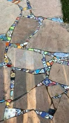 a stone walkway made out of different colored glass tiles