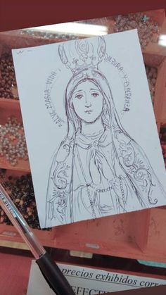 a drawing of the virgin mary is shown on a piece of paper next to some seeds