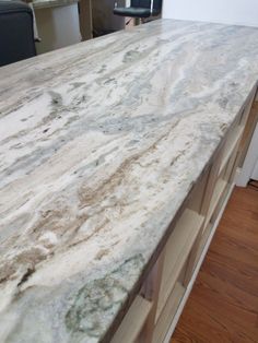 a marble counter top in the middle of a kitchen