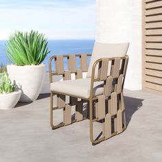 a chair sitting on top of a patio next to a potted plant