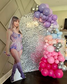 a woman standing in front of a balloon arch