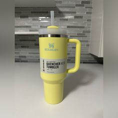 a yellow travel mug sitting on top of a counter