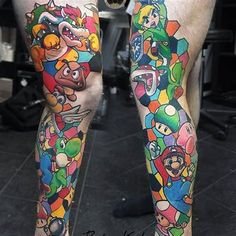 the legs are covered with many different colored tattoos on them, including an image of mario and luigi