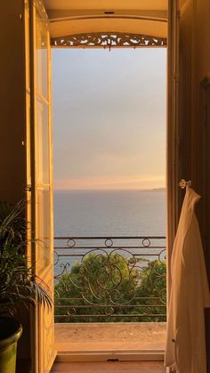 an open door leading to a balcony overlooking the ocean