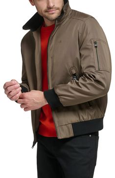 Every closet craves this edgy bomber styled with handy side pockets, a water-resistant finish and comfy ribbed trim. Front zip closure Stand collar Front zip pockets Ribbed cuffs and hem Water resistant Lined 100% polyester Machine wash, line dry Imported Nylon Track Jacket With Zipper Closure For Fall, Casual Nylon Outerwear With Zip Cuffs, Fall Nylon Track Jacket With Zipper Closure, Casual Track Jacket With Zipper Closure For Outdoor Activities, Casual Outerwear With Zip Cuffs For Outdoor, Casual Calvin Klein Fall Outerwear, Calvin Klein Casual Fall Outerwear, Sporty Calvin Klein Fall Outerwear, Dark Tan