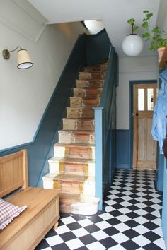 the stairs are made of wood and have been painted blue with black and white checkered flooring