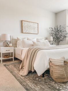 a bedroom with a bed, nightstands and baskets on the floor in front of it