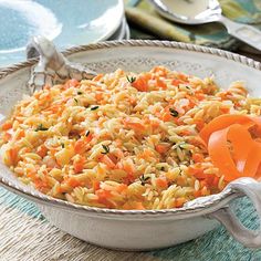 a bowl filled with rice and carrots on top of a table