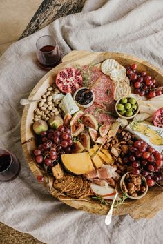 a wooden platter filled with different types of cheese and meats