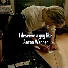 a man writing on a piece of paper with the caption, i deserves a guy like aaron warnner