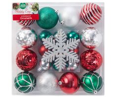 assorted christmas ornaments in a box with white snowflake and red and green baubles