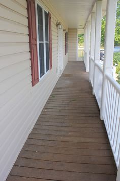 a long white porch with red shutters on both sides