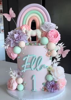 a birthday cake decorated with pastel colors and flowers