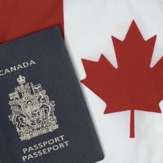 a canadian passport sitting next to a canadian flag