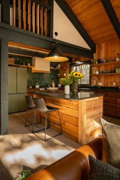 an open kitchen and living room area with wood paneling