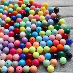 many different colored beads are laying on the floor next to each other and they look like balls