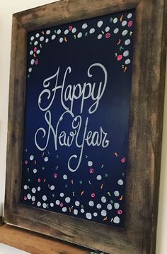 a happy new year's chalkboard hanging on the wall