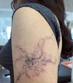 a woman's arm with a flower tattoo on the left side of her arm