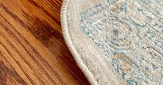 a close up of a rug on the floor with a wooden surface in the background